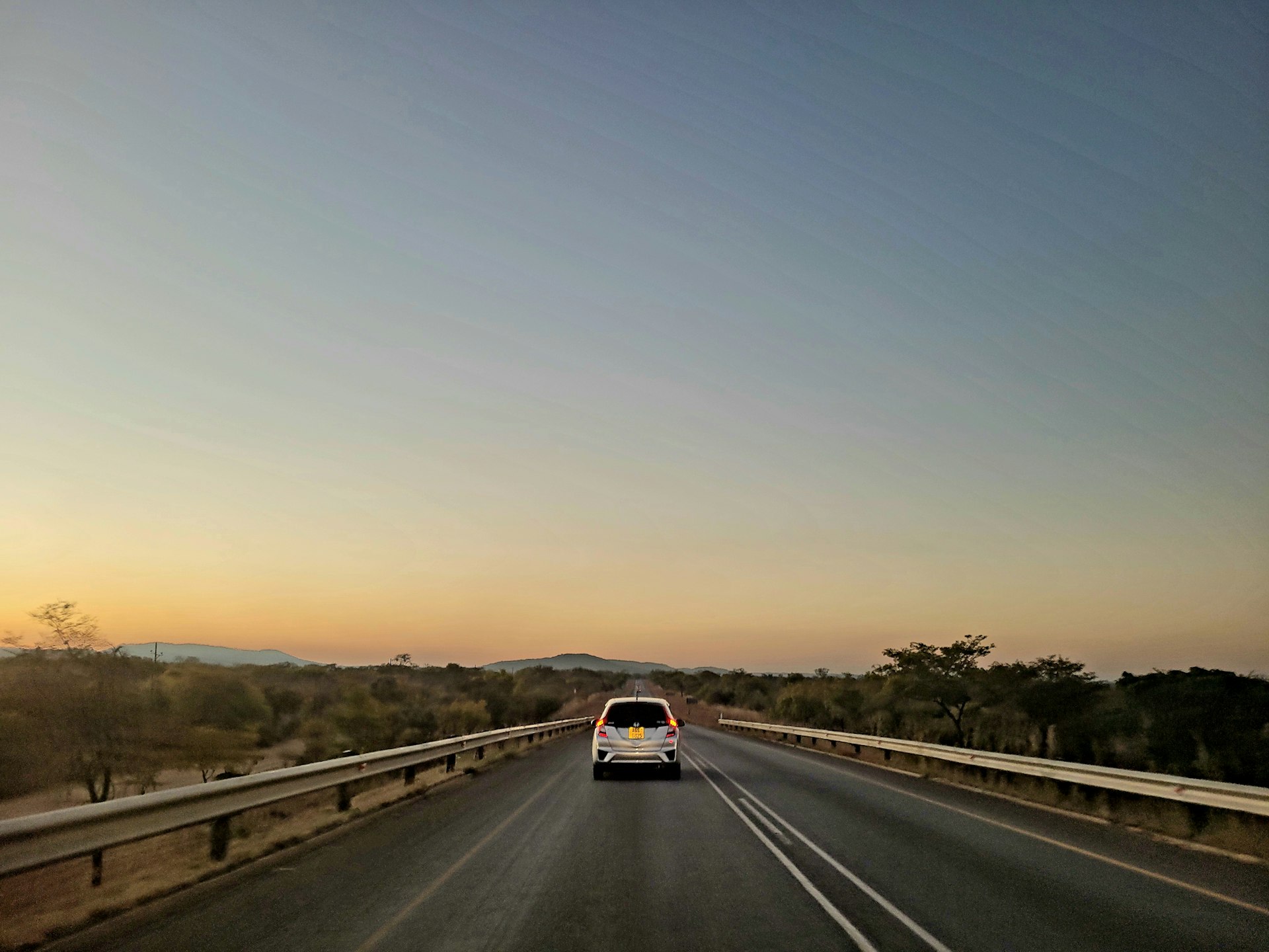 A car driving down a highway at sunset